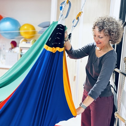Ergothérapeute installant une balançoire sensorielle, utilisée pour le travail de l'intégration neuro-sensorielle
