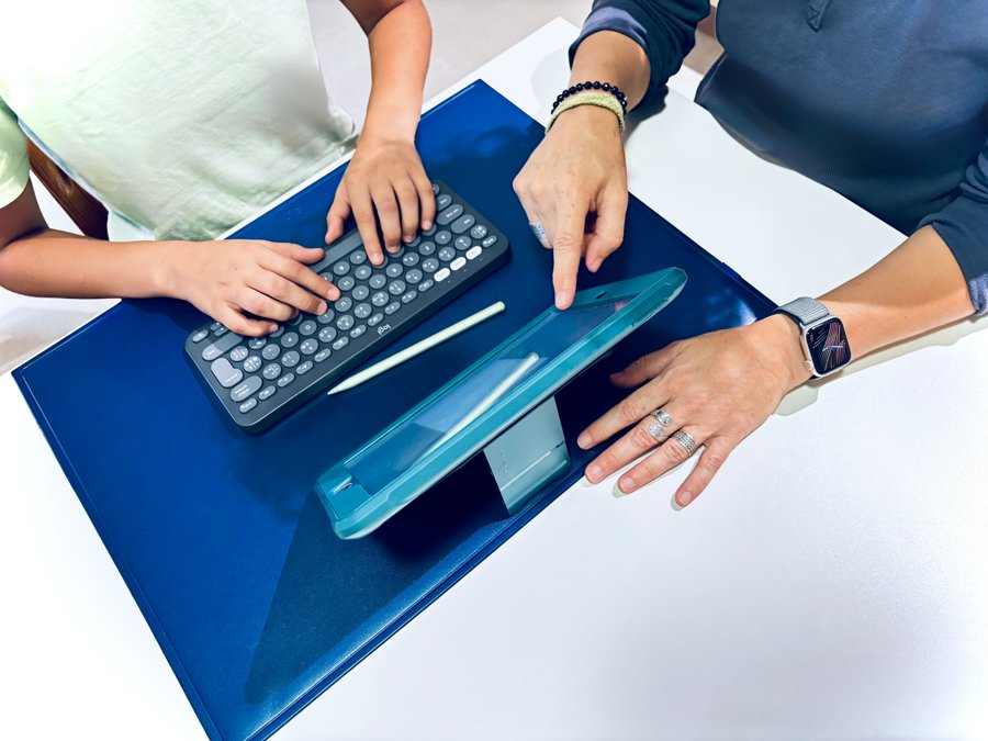 Enfant et parent utilisant une tablette et un clavier en compensation numérique